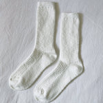 Pair of white socks on a light gray background