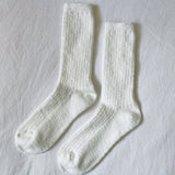 Pair of white socks on a light gray background