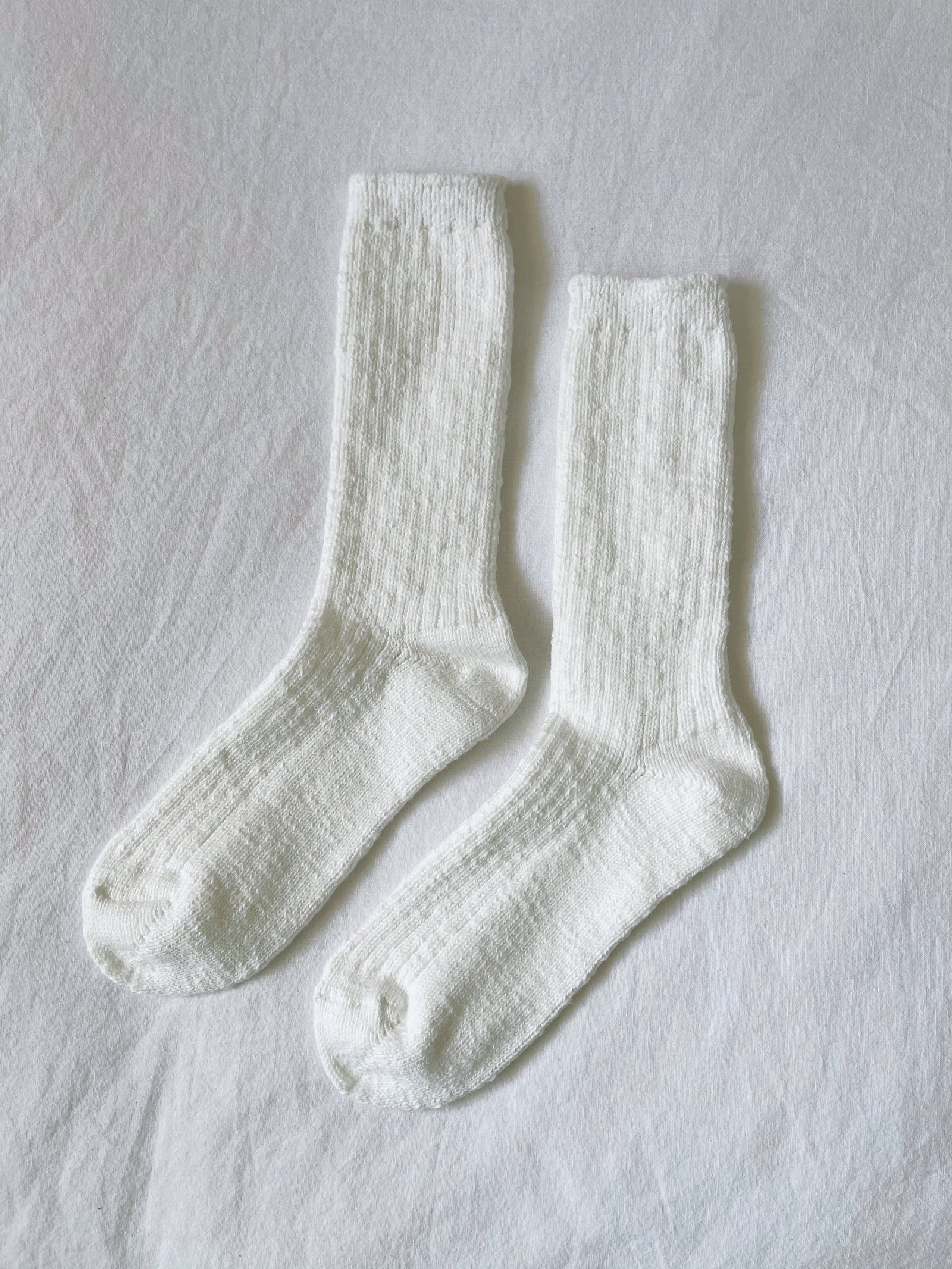 Pair of white socks on a light gray background