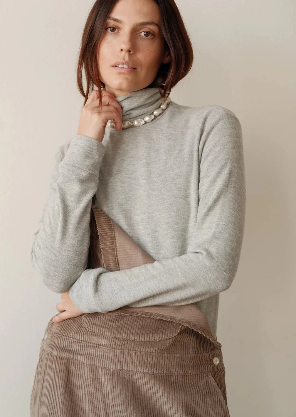 Medium close image of a female model wearing the Sweater Turtleneck in Heather Grey