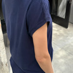 Person wearing a navy blue t-shirt in an indoor setting