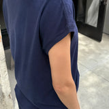 Person wearing a navy blue t-shirt in an indoor setting