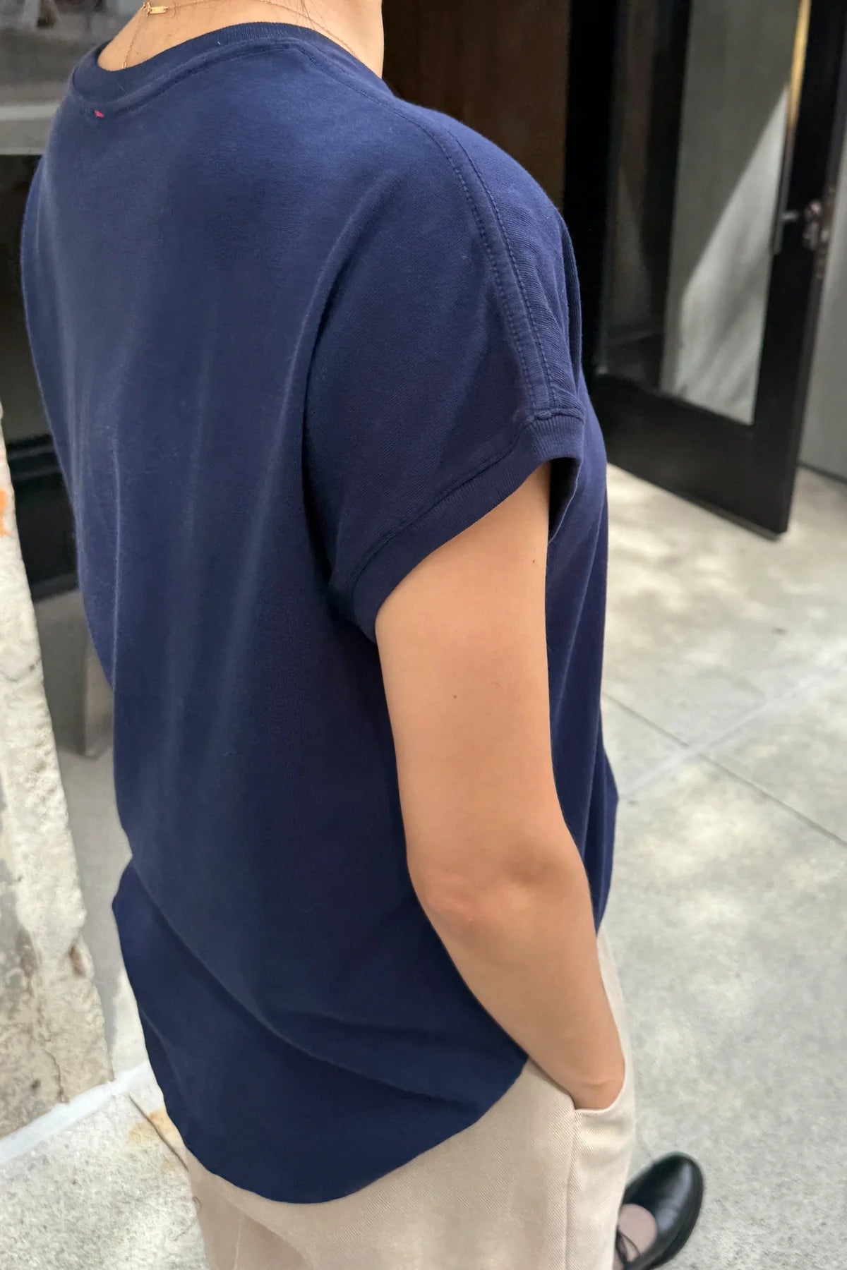 Person wearing a navy blue t-shirt in an indoor setting