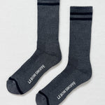 Pair of gray socks with black stripes and 'Le Bon Shoppe' branding on a light gray background