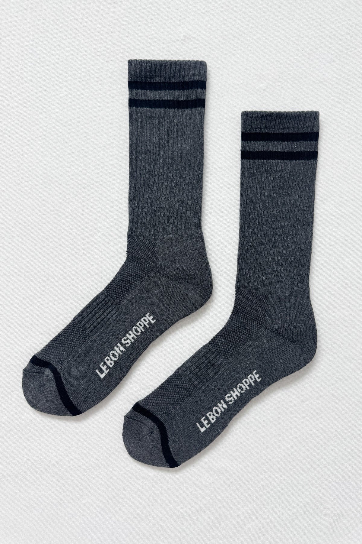 Pair of gray socks with black stripes and 'Le Bon Shoppe' branding on a light gray background