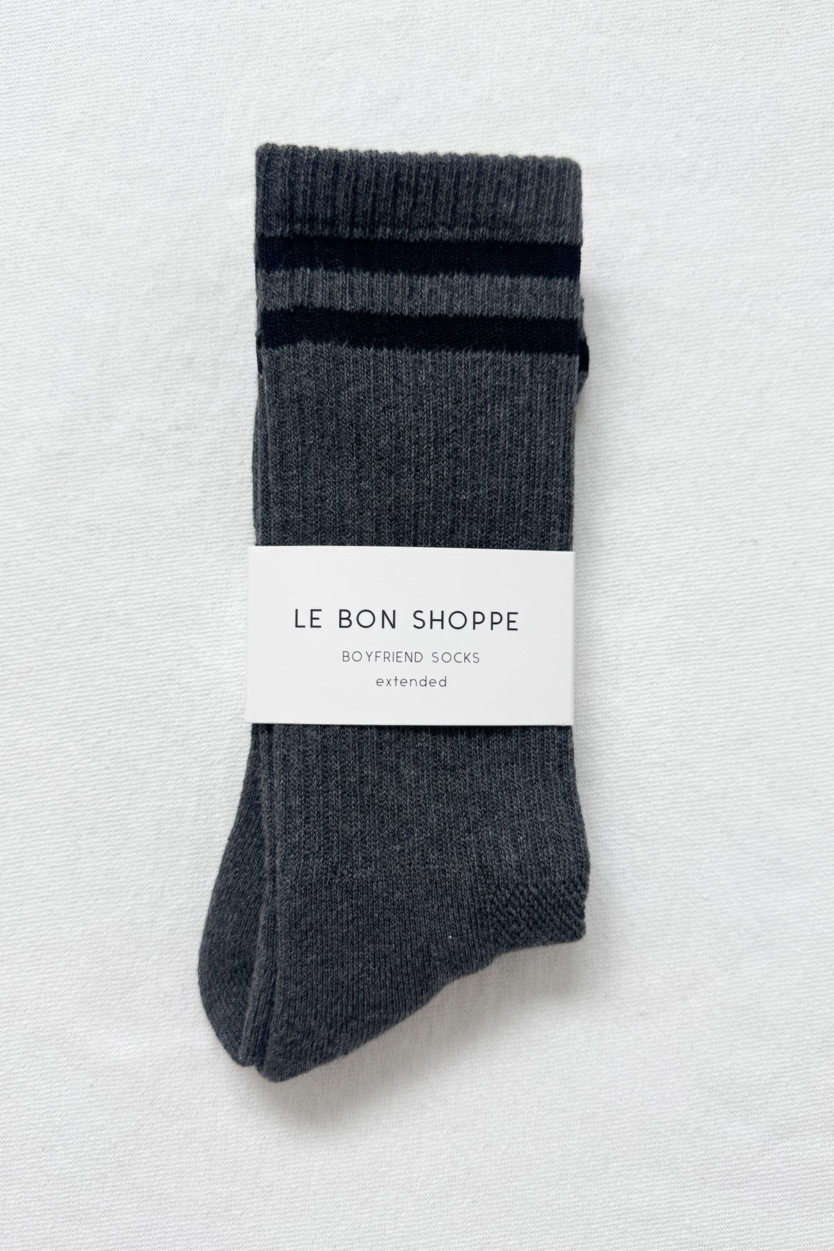 Pair of gray socks with a label on a light gray background