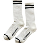 White socks with black stripes and Le Bon Shoppe branding on white background
