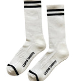 White socks with black stripes and Le Bon Shoppe branding on white background