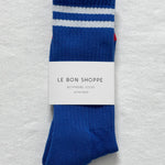 Cobalt socks with white stripes in Le Bon Shoppe packaging on white background.