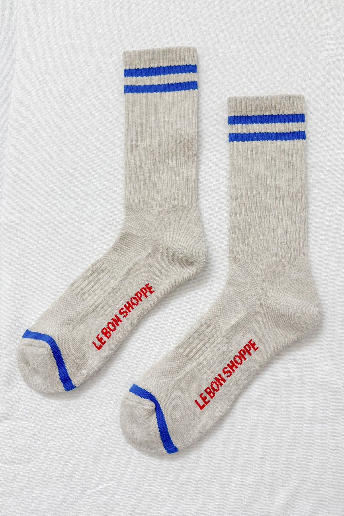 Pair of gray socks with blue stripes and red text on a white background