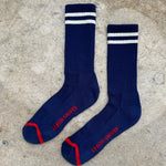 A pair of navy blue extended boyfriend socks with a white and red stripe on the ankle area.