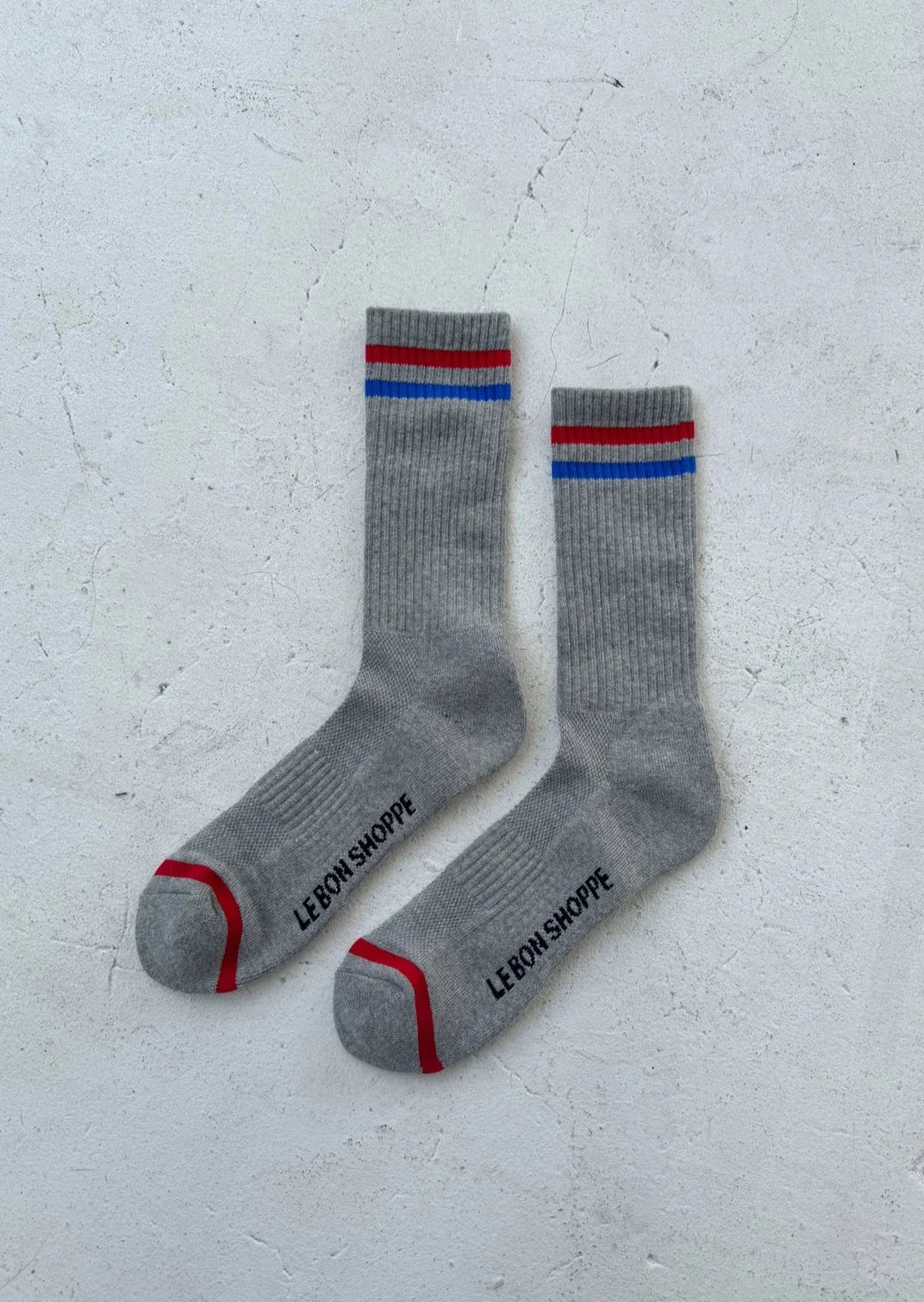 Grey socks with red and blue stripes on white background