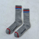 Grey socks with red and blue stripes on white background