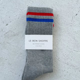 Grey socks with red and blue stripes in white Le Bon Shoppe packaging on white background