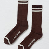 Pair of brown socks with white stripes and 'Le Bon Shoppe' branding on a light gray background