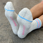 Gray socks with blue and pink accents on a concrete surface