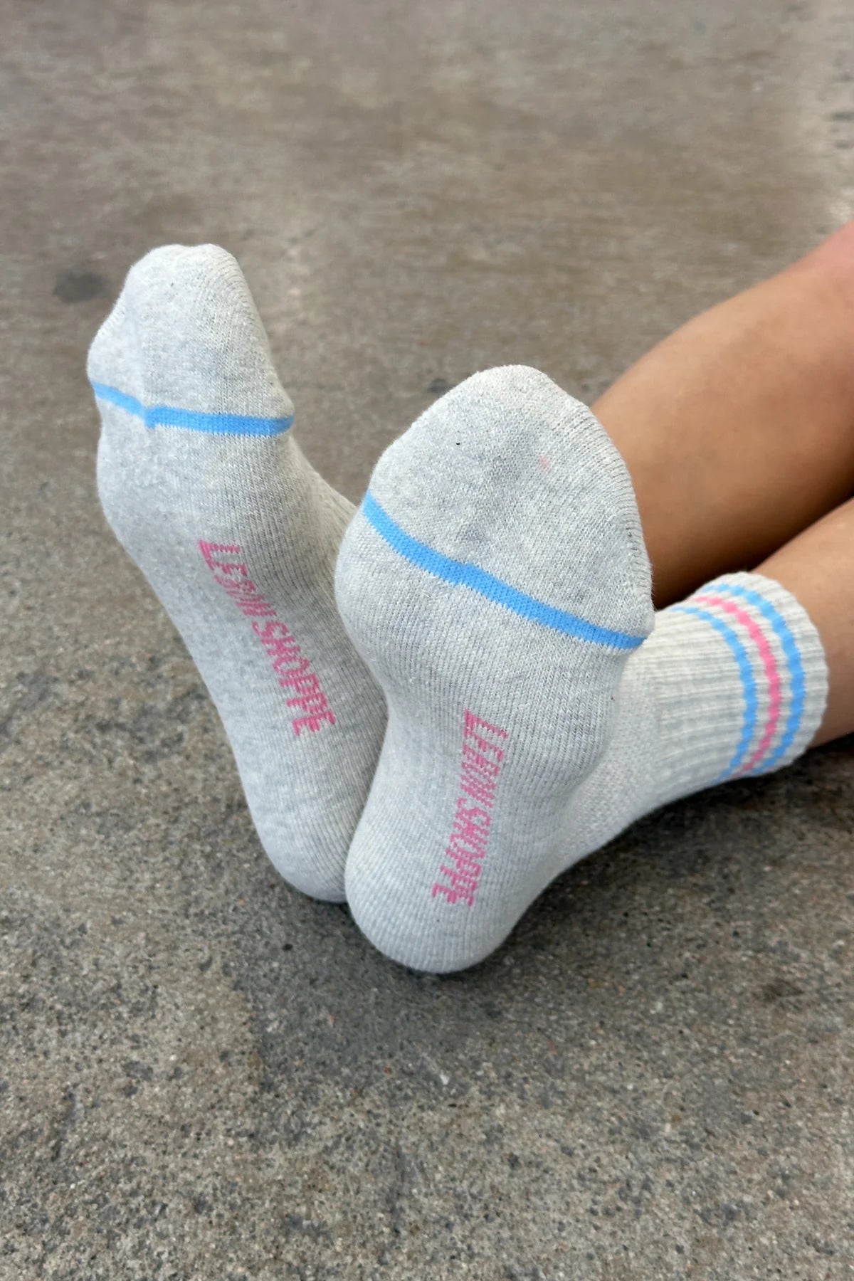 Gray socks with blue and pink accents on a concrete surface