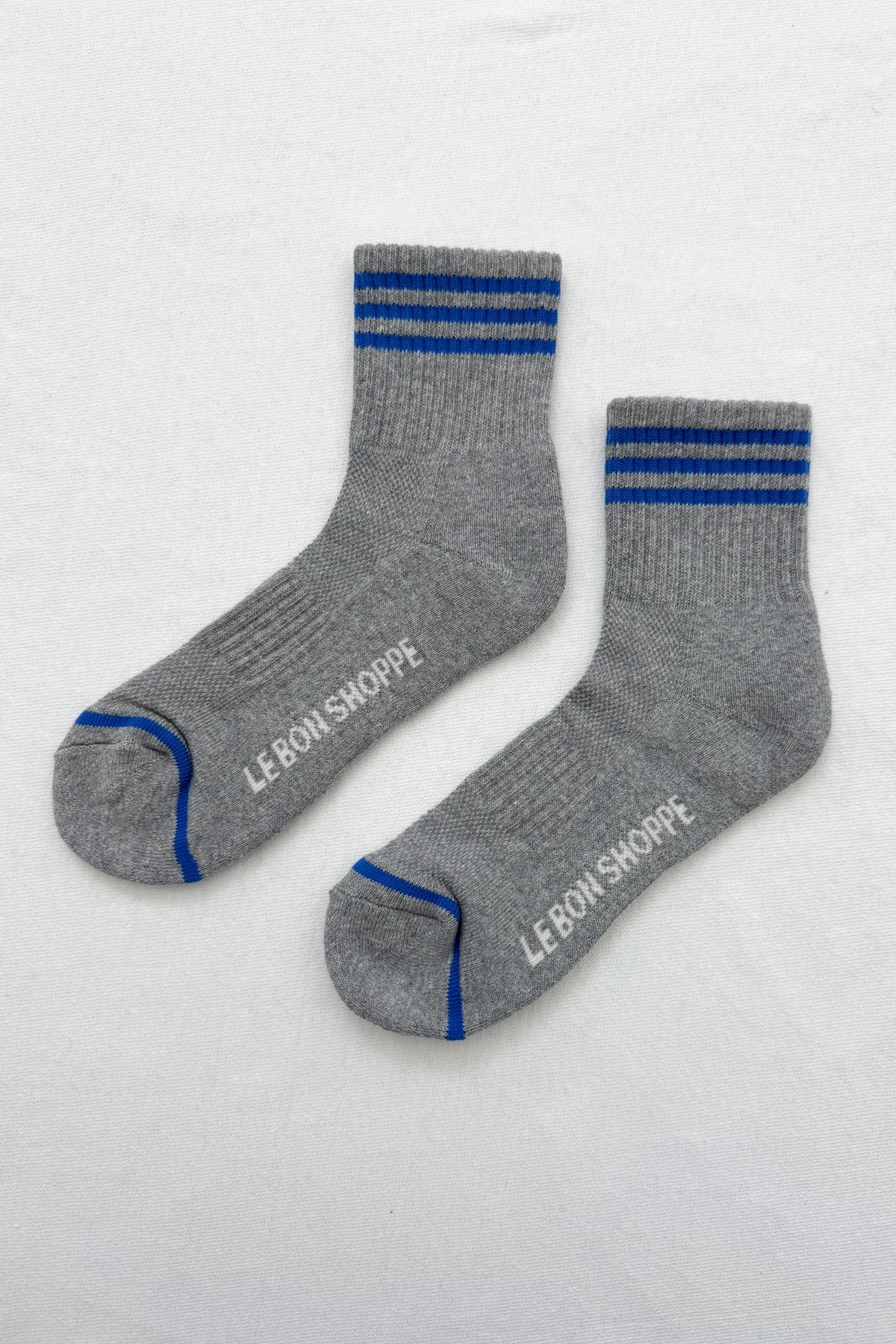 Grey socks with blue stripes on a white background