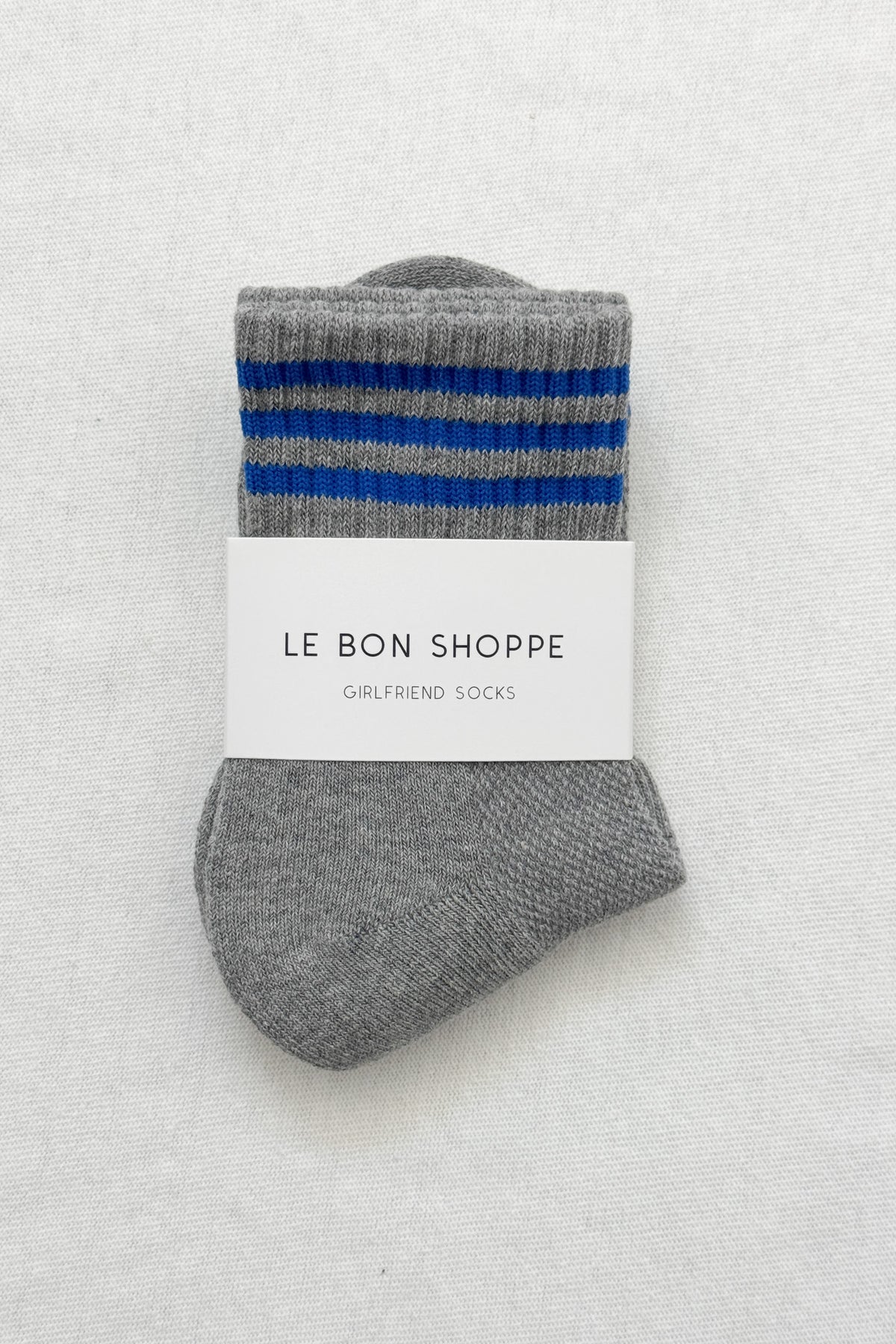 Grey socks with blue stripes in white Le Bon Shoppe packaging on white background