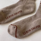 Pair of brown socks with 'Le Bon Shoppe' branding on a light background
