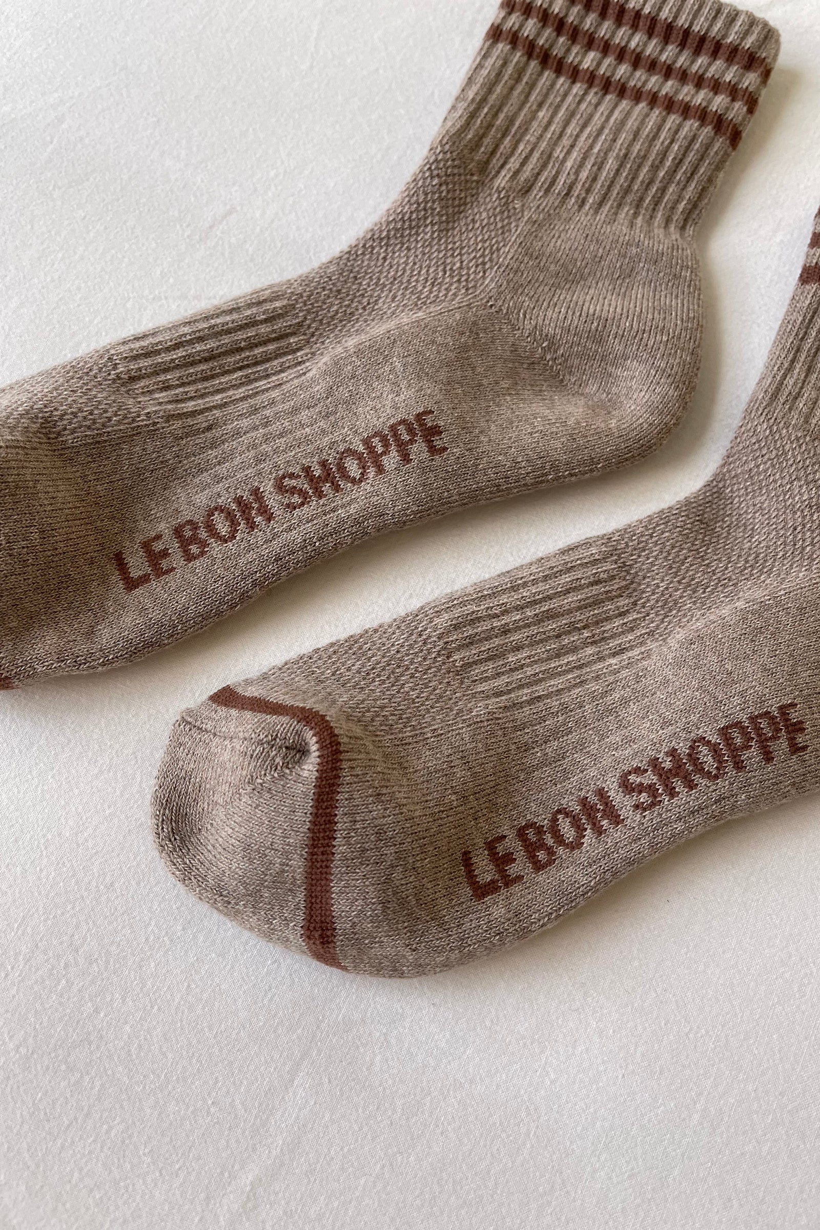 Pair of brown socks with 'Le Bon Shoppe' branding on a light background