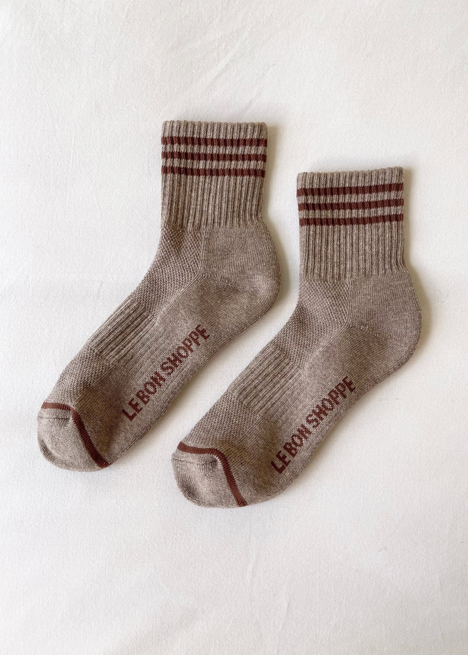 Pair of brown socks with striped pattern on a white background