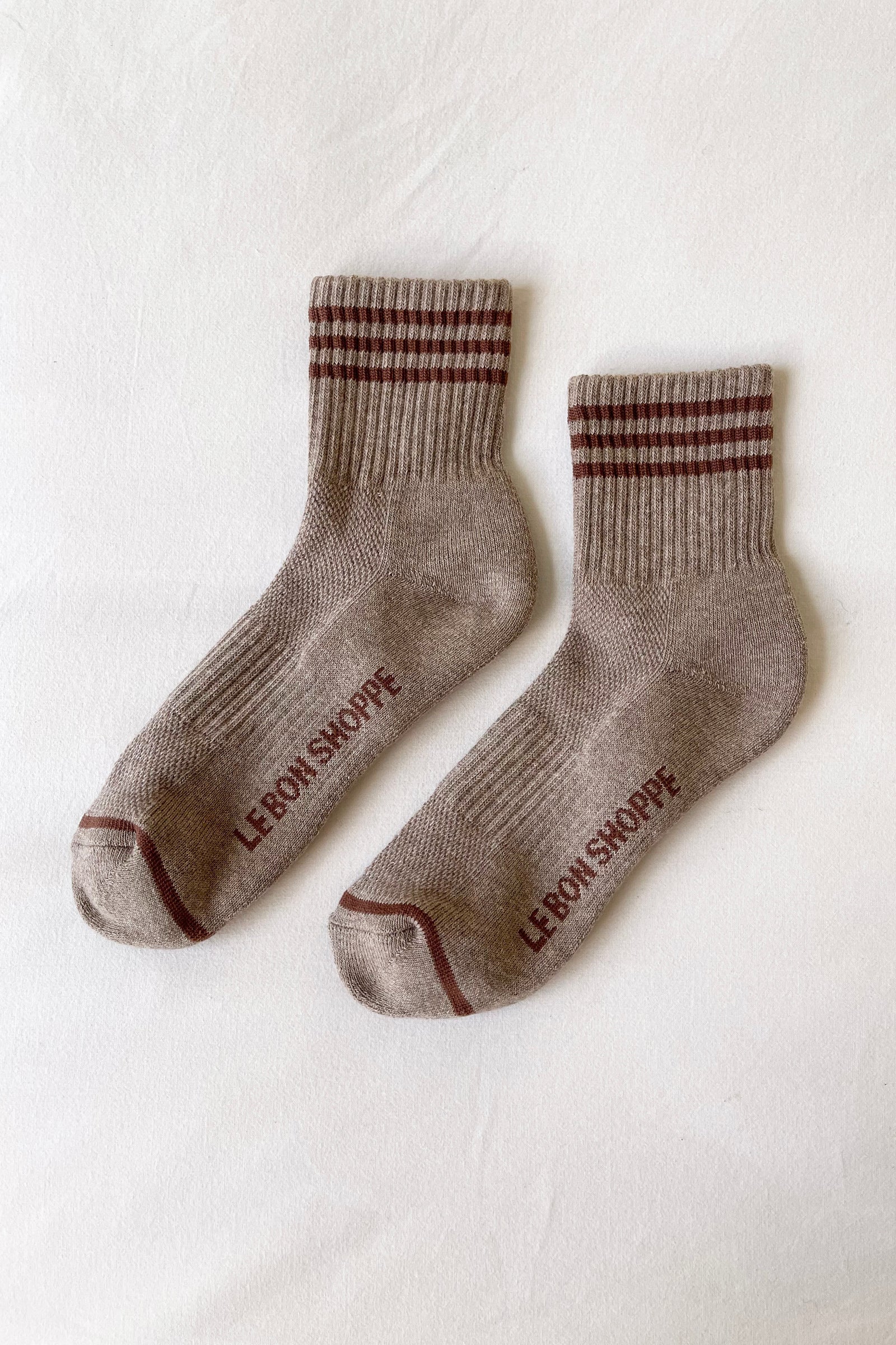 Pair of brown socks with striped pattern on a white background