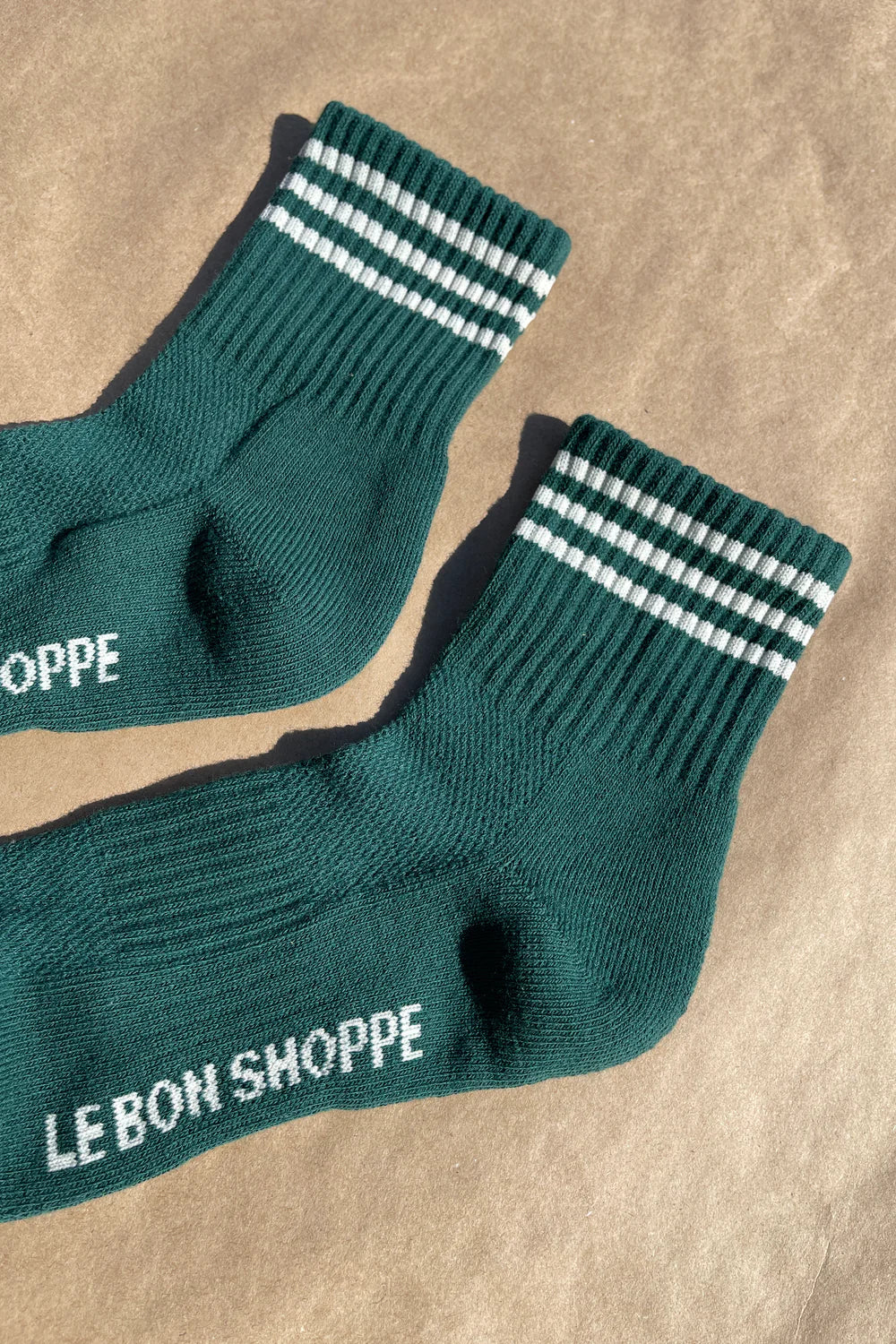 Green socks with white stripes on kraft paper background