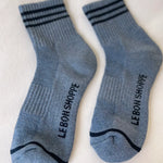 Blue socks with navy stripes and Le Bon Shoppe branding on white background