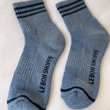 Blue socks with navy stripes and Le Bon Shoppe branding on white background