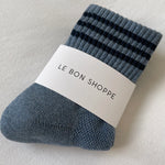 Blue shoes with navy stripes in white Le Bon Shoppe packaging on white background