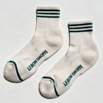 White socks with black text and green accents on a light gray background