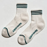 White socks with black text and green accents on a light gray background
