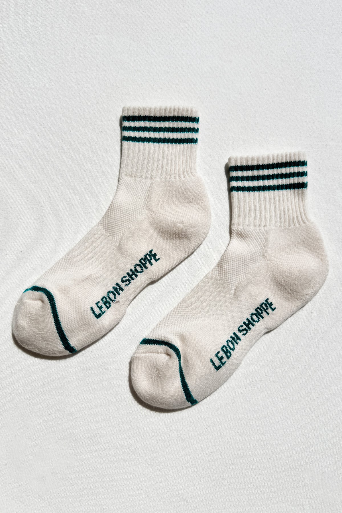 White socks with black text and green accents on a light gray background