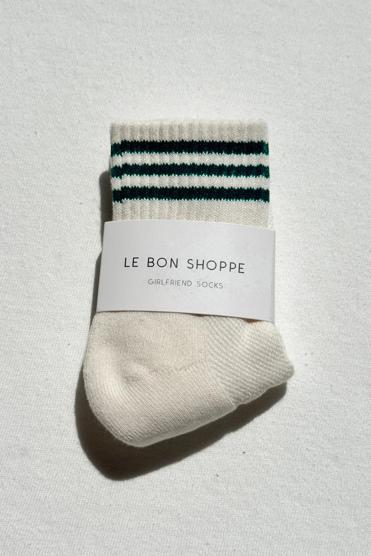 Pair of socks with striped pattern and 'Le Bon Shoppe' label on a light background