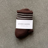 Brown socks with white stripes in white Le Bon Shoppe packaging on concrete floor