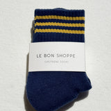 Pair of blue socks with yellow stripes and a visible brand label on a light gray background