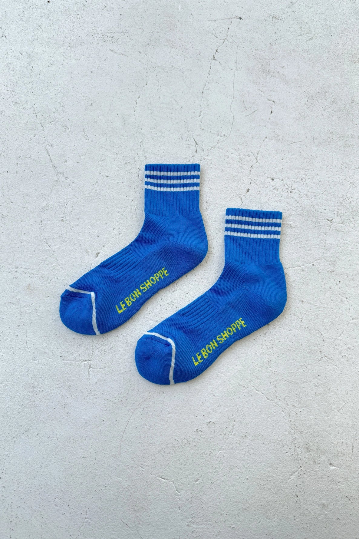 Blue socks with white stripes on light grey backgound