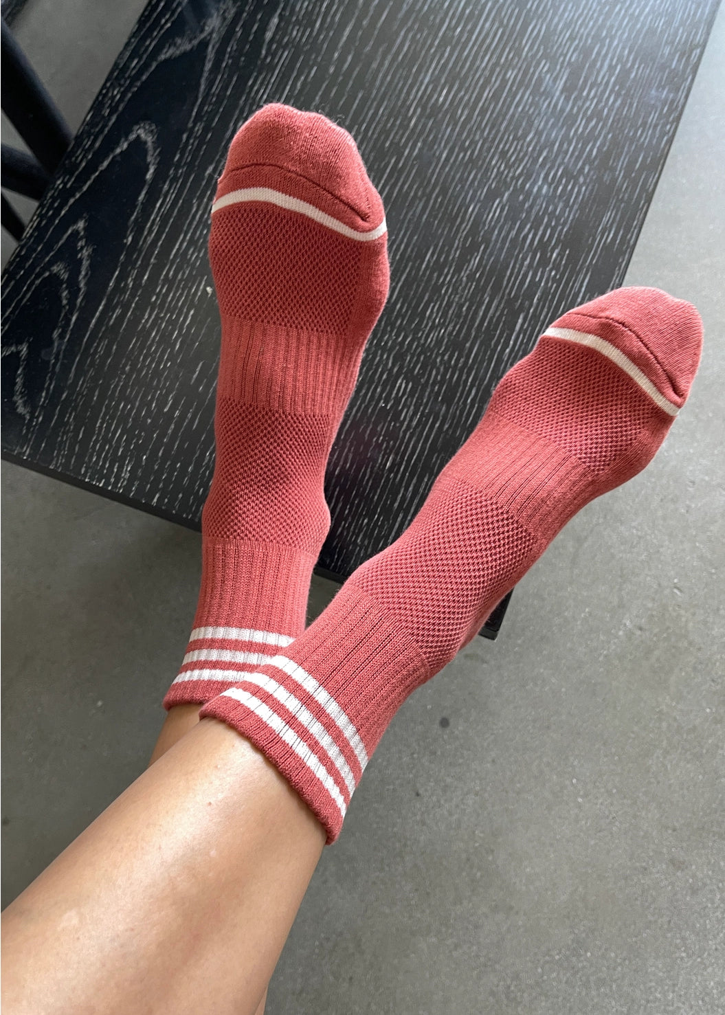 Red socks with white stripes on a black surface