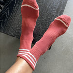 Red socks with white stripes on a black surface