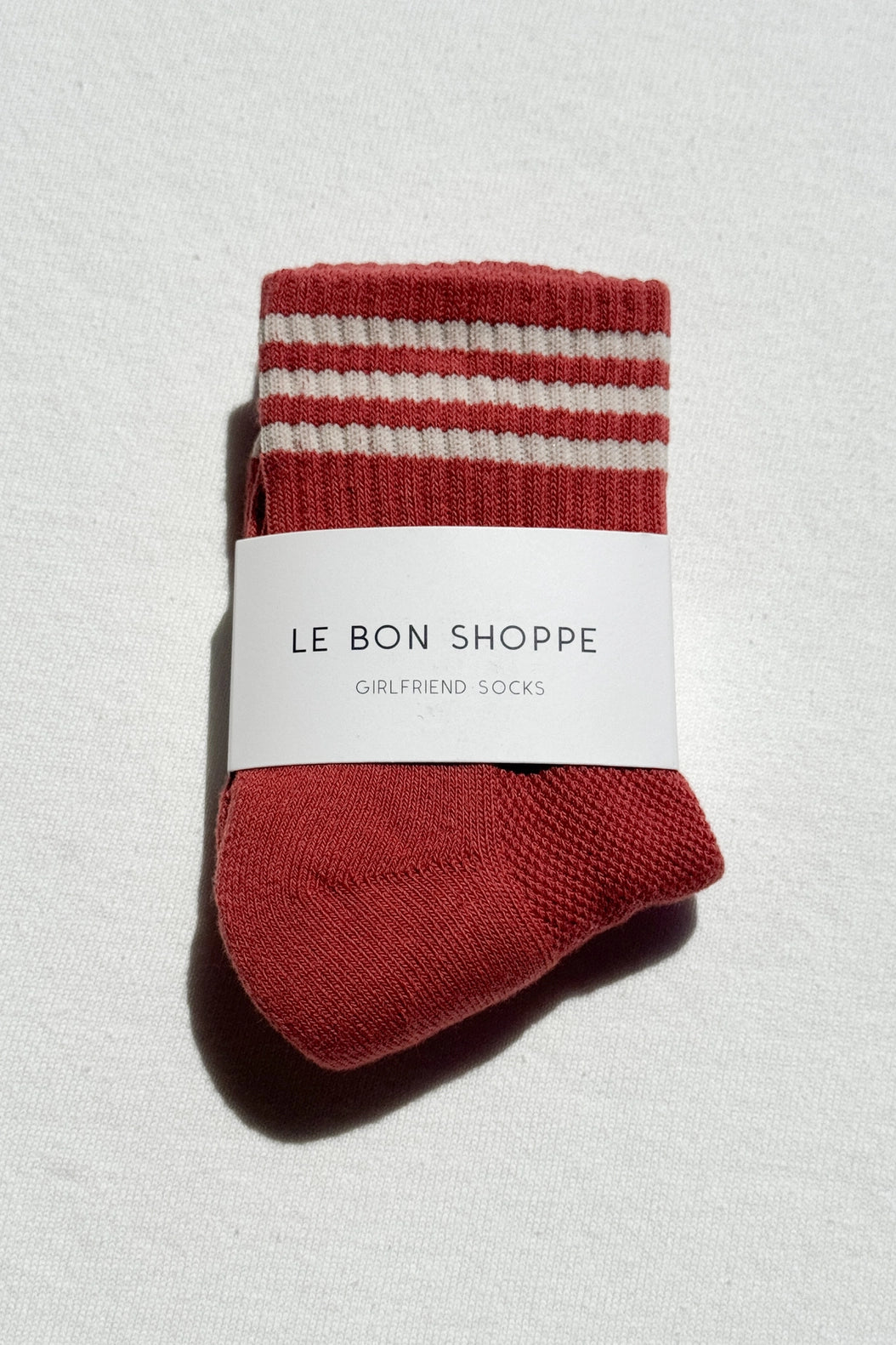 Red and white striped socks with a label on a light gray background