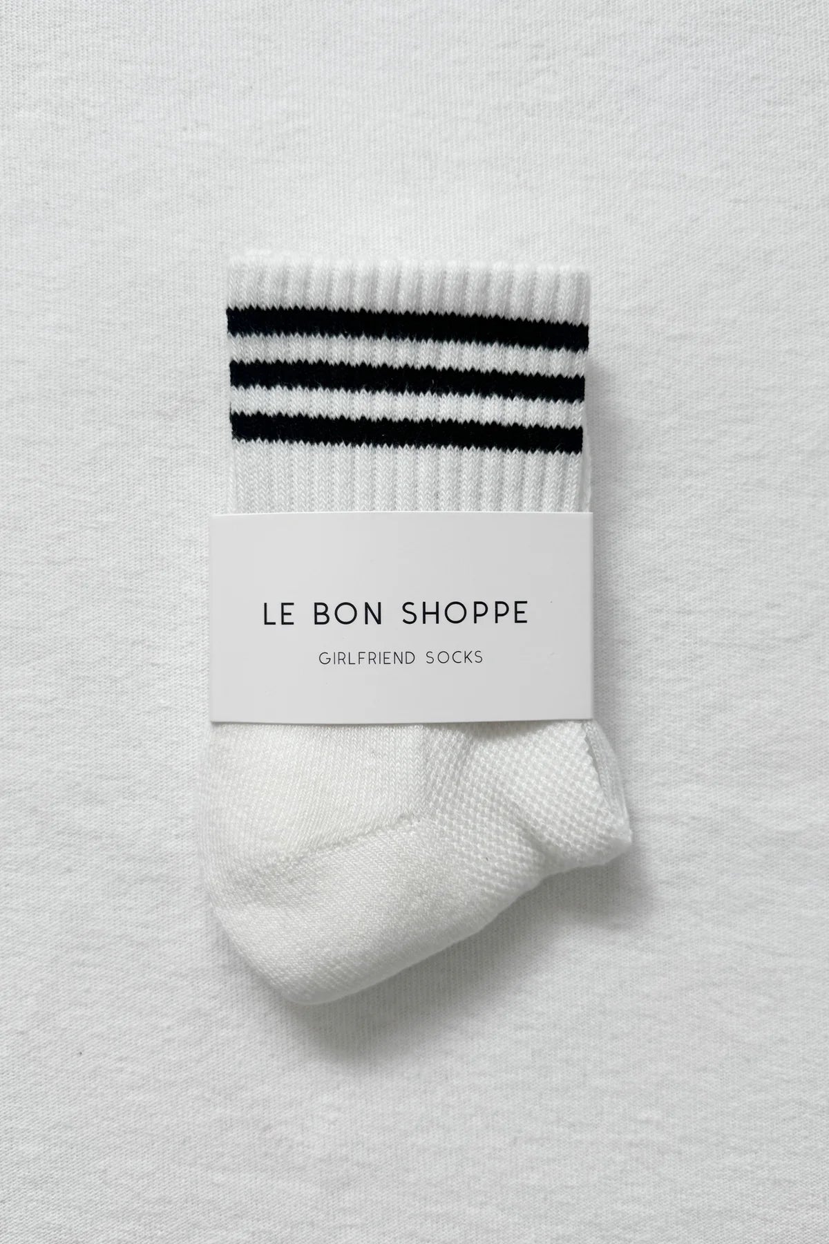 White sock with black stripes on a white background, featuring 'Le Bon Shoppe' packaging.