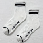 White socks with black stripes and 'LE BON SHOPPE' text on a light gray background
