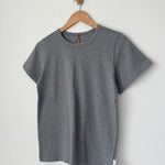 Gray t-shirt on a wooden hanger against a light gray background