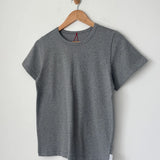Gray t-shirt on a wooden hanger against a light gray background
