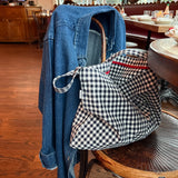 Blue denim jacket and checkered bag on a chair in a restaurant setting