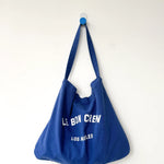 Blue tote bag with text on a white background