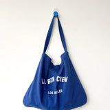 Blue tote bag with text on a white background