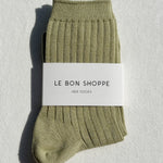 Green sock with a white label on a light gray background