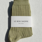 Green sock with a white label on a light gray background